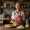 a_warm_rustic_southern_kitchen_with_a_smiling_middle-aged_woman_in_a_gingham_apron_serving_a_plate__